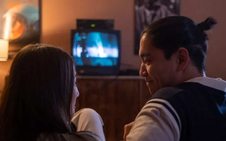 Dos personas ven la televisión de noche en un sillón